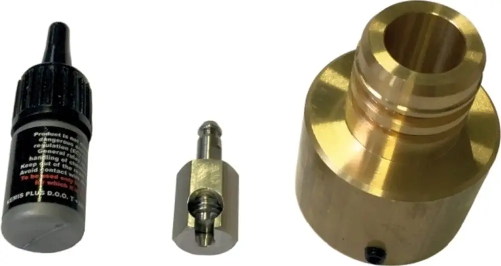Drei Metallkomponenten, darunter ein Adapter, eine Düse und ein Fläschchen, die möglicherweise zur Installation oder Wartung von Wolf-VRG-Systemen genutzt werden.